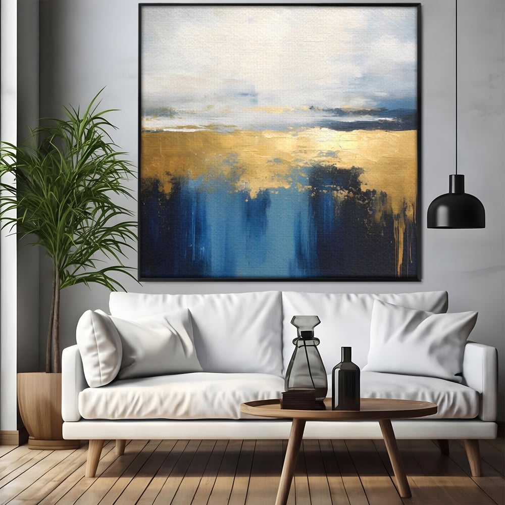 Tablou canvas cu pictura abstracta cu tonuri aurii si albastre, in rama de aluminiu negru, pe perete intr-un living
